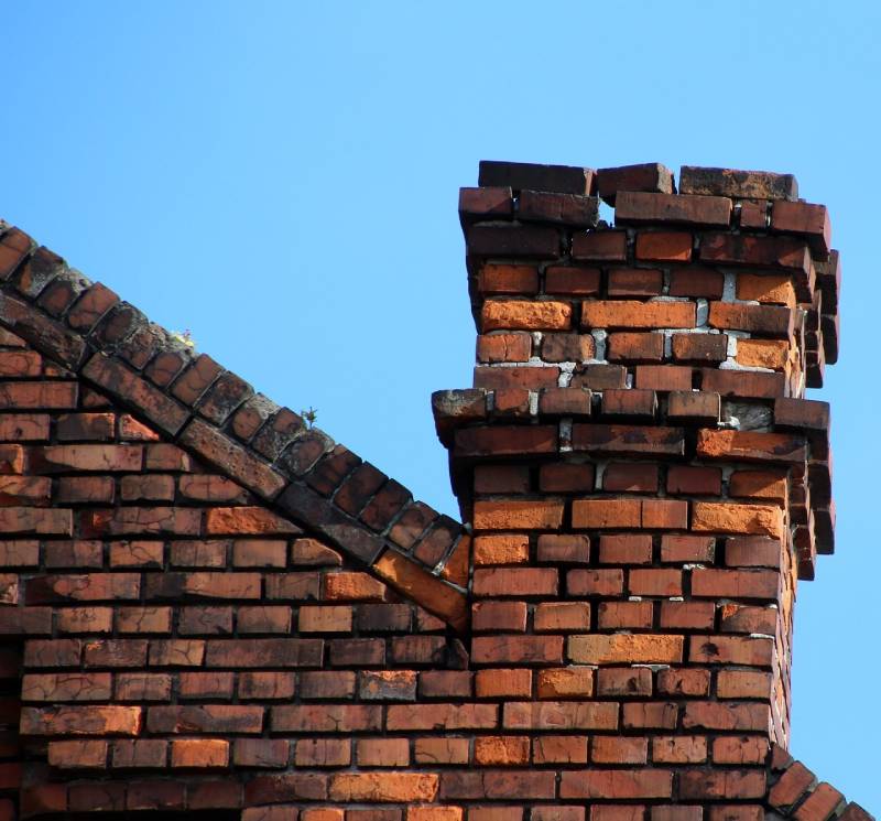 Damaged chimney on an Chicago home showing cracks and missing mortar